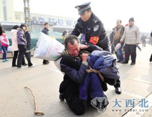 1月8日，山西太原火車站，一位沒有身份證的老農(nóng)滯留車站廣場，一民警幫他辦理臨時身份證、購票，老農(nóng)才順利上車。圖為老農(nóng)跪謝民警，民警幫老人扛好行李。 